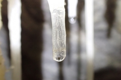 Formation d'une stalactite par cristallisation de calcite blanche.